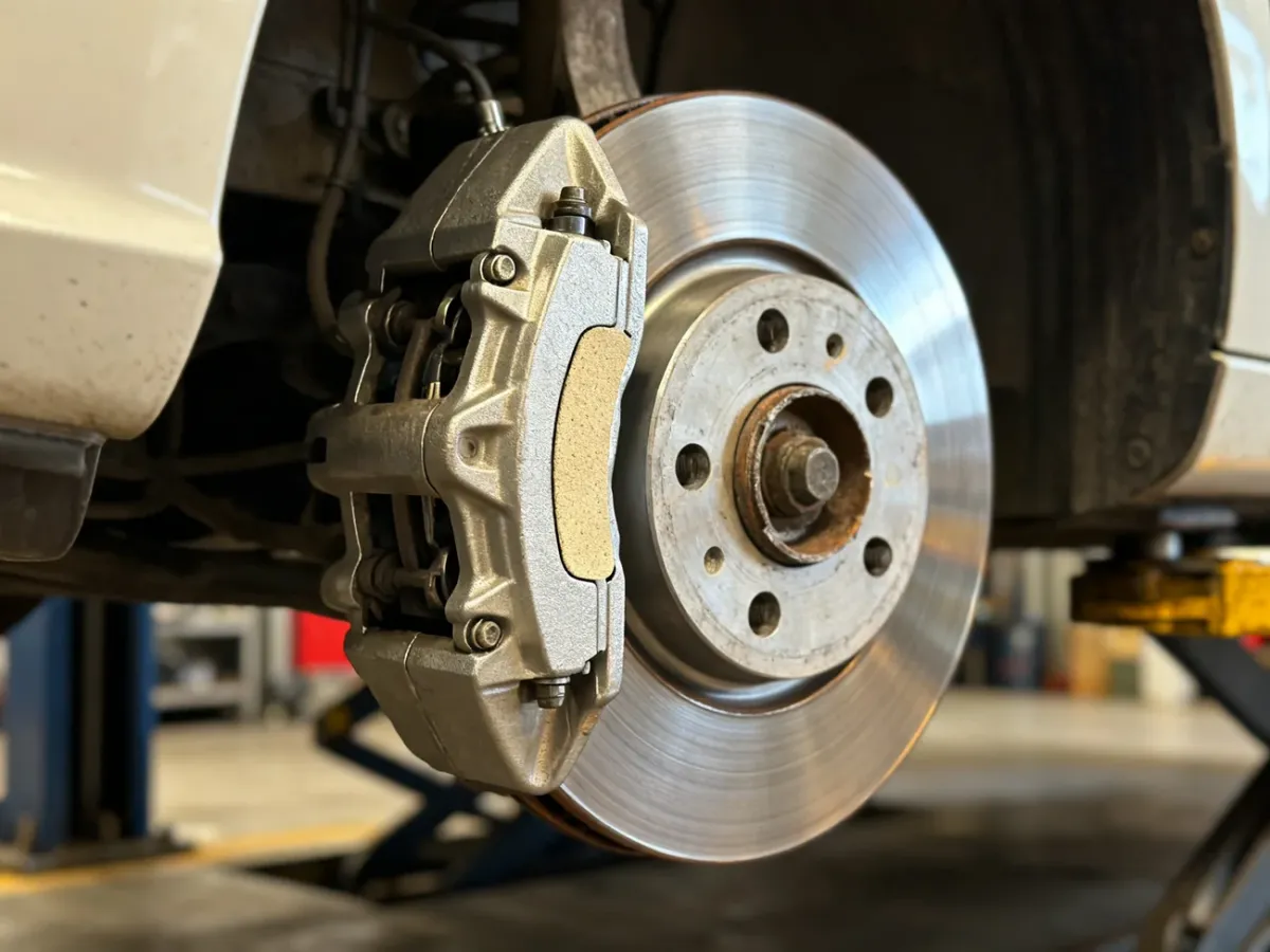 Ceramic brake pad mounted next to a clean brake disc with minimal dust