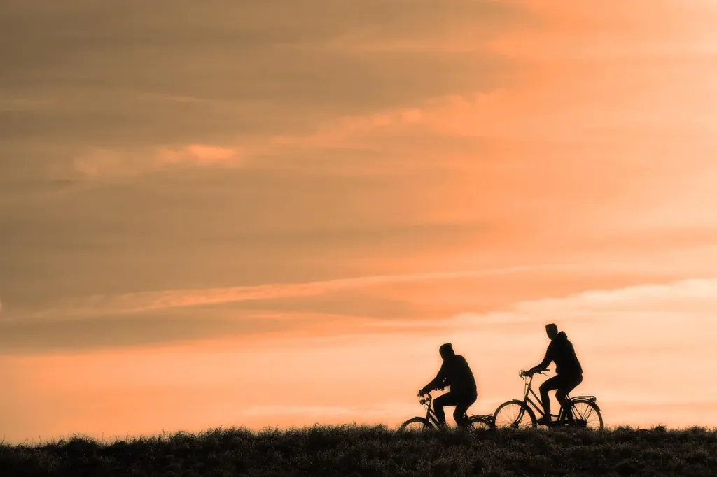 Rowerzysta jadący szosą przez malowniczy krajobraz, podkreślający aktywny tryb życia na łonie natury.