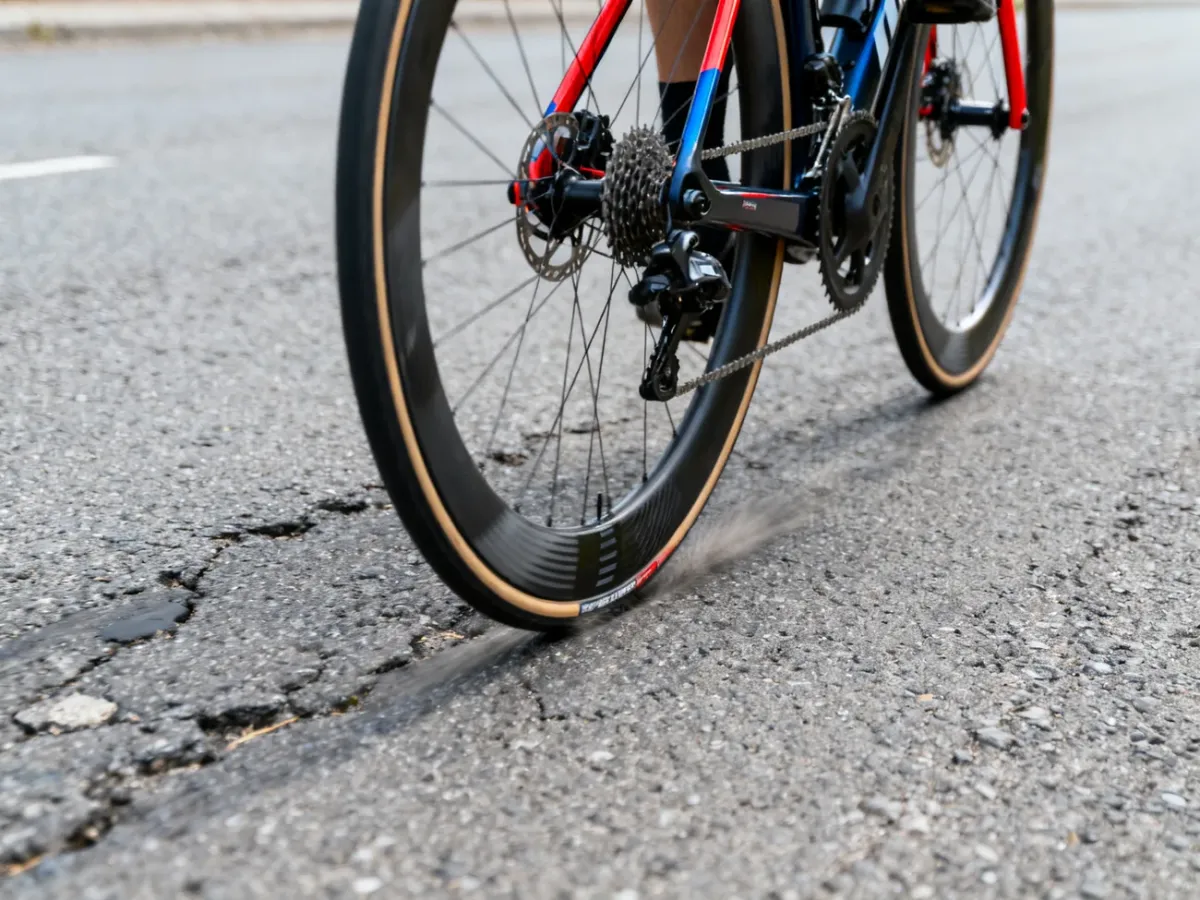 Koło roweru szosowego z oponą tubeless na nierównym asfalcie
